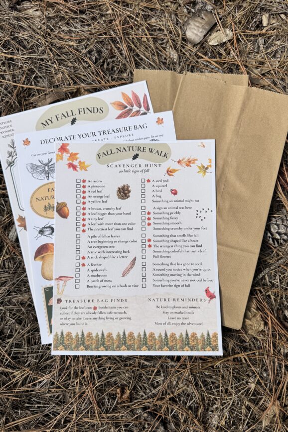 Fall nature scavenger hunt printable with a 40-item checklist, nature journal, botanical treasure bag decorations, and brown paper bags arranged on a woodland floor.
