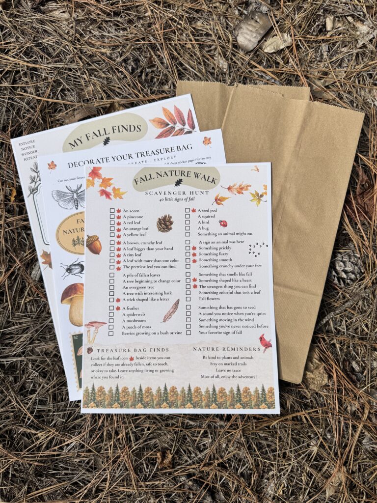 Fall nature scavenger hunt printable with a 40-item checklist, nature journal, botanical treasure bag decorations, and brown paper bags arranged on a woodland floor.